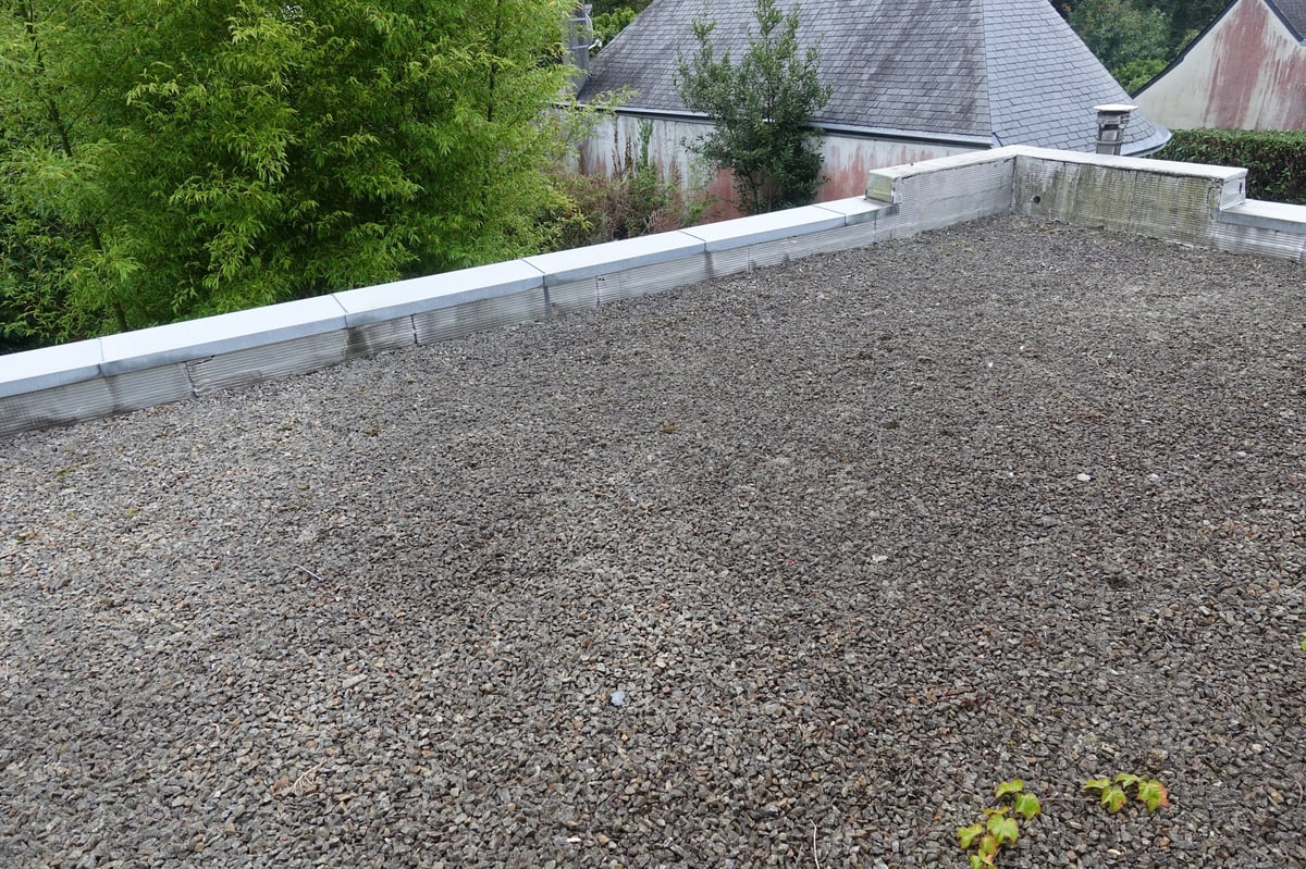 Flat roof with gravels of an urban city dwelling house